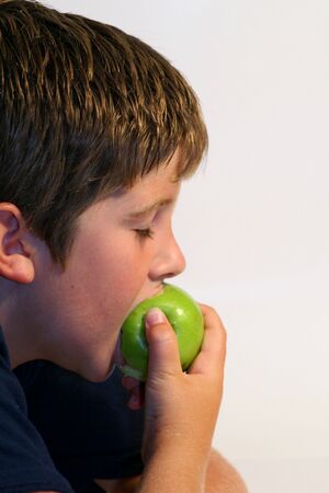 Young boy eating an appleの写真素材