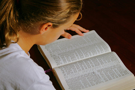 young girl reading the bible
