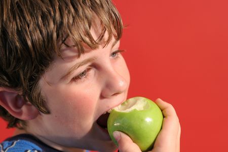 boy eating an appleの写真素材