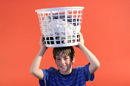 boy with laundry basket on headの写真素材