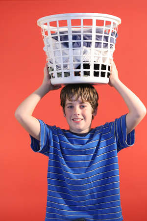 boy with laundry basket on head verticalの写真素材