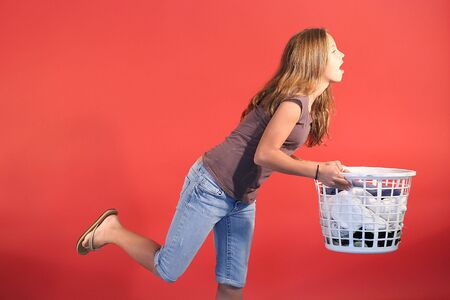 girl tripping with laundryの写真素材