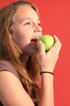 girl eating an apple verticalの写真素材