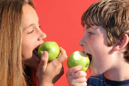 boy & girl eating an apple upcloseの写真素材