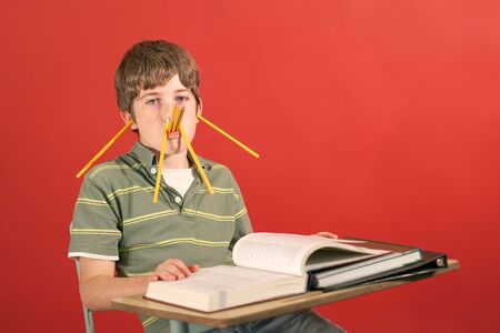 kid showing off being silly with pencilsの写真素材