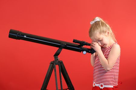 pretty young girl looking thru telescope の写真素材