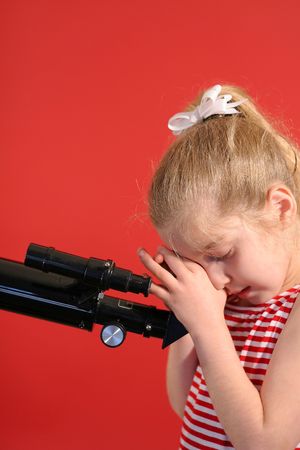 pretty young girl looking thru telescope verticalの写真素材
