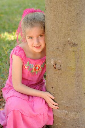 little girl hugging treeの写真素材