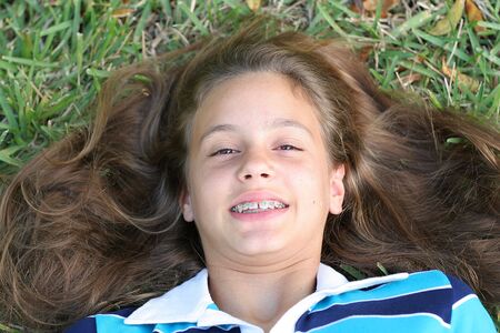 girl laying in grass on topの写真素材