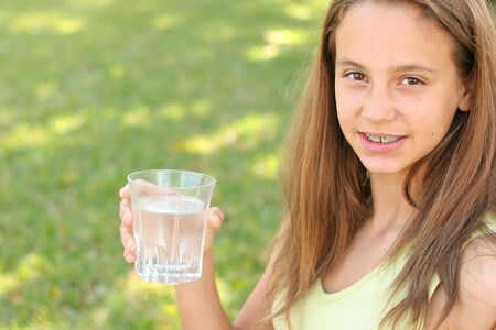 young girl drinking a glass of waterの写真素材
