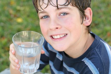boy drinking a glass of water smileの写真素材