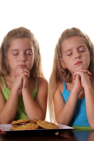 Identical twin girls saying graceの写真素材