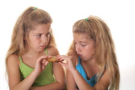 two children fighting over cookieの写真素材