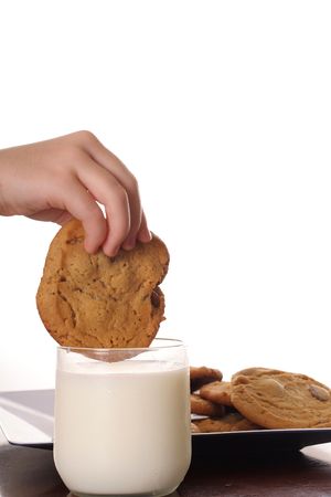 dipping cookie in milk upclose verticalの写真素材
