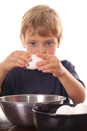 little boy breaking an eggの写真素材