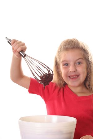 happy little girl mixing brownie batter verticalの写真素材