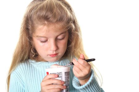 little girl looking at her yogurtの写真素材