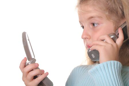 young girl talking on a cell phone looking at another phoneの写真素材