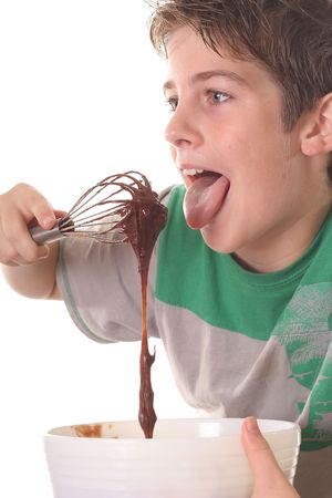 young boy licking chocolate batterの写真素材
