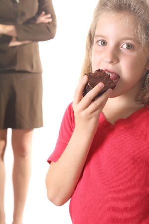 Child eating brownie - mom not happyの写真素材