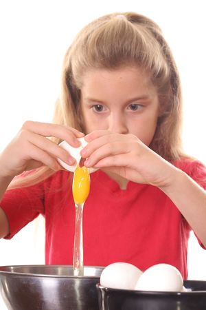 little girl cracking an eggの写真素材
