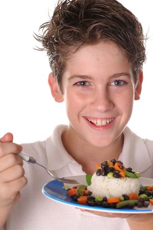 happy young boy eating healthy rice, beans & veggies verticalの写真素材
