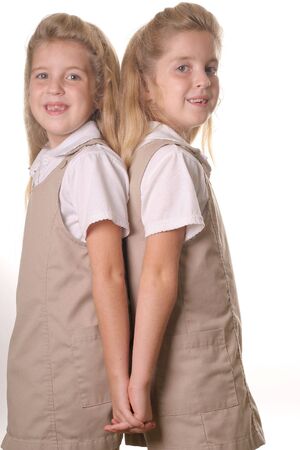 twin school girls vertical holding hands backの写真素材