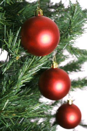 red christmas ornaments on tree in a lineの写真素材