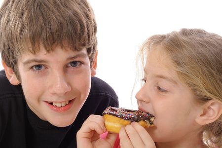brother and sister eating a doughnutの写真素材
