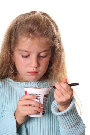 little girl looking at her yogurt verticalの写真素材