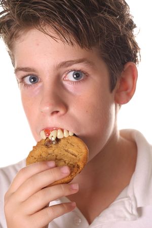 young boy with rotten teeth eating a cookieの写真素材