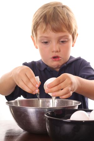 little boy cracking an eggの写真素材