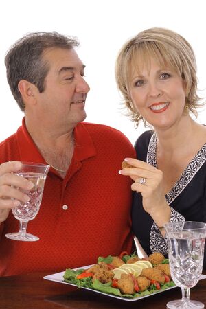 middle aged couple having appetizers verticalの写真素材