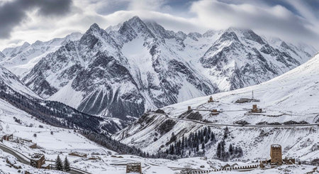 A snowy mountain range with a village and trees in the foreground under a cloudy sky.