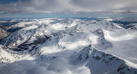 Winter mountains panorama with snow covered peaks and blue sky with clouds