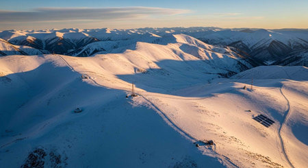 Aerial panoramic view of snow covered mountains at sunset.の写真素材