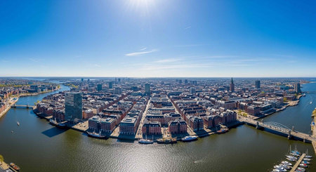 Aerial view of a modern cityscape with a river and clear blue sky