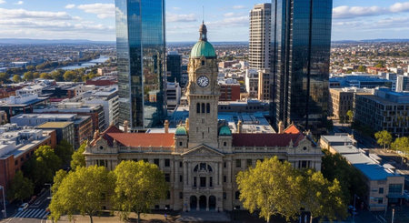 Aerial view of a historic building in a modern city with a clock tower and skyscrapers