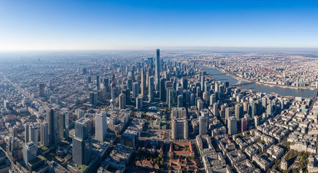 Aerial view of a bustling metropolis with skyscrapers and a river under a clear blue sky