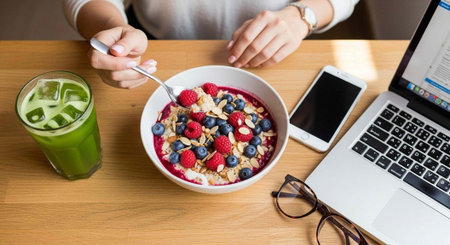 Woman eating healthy breakfast with fresh berries, yogurt and green smoothie