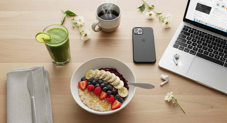 Healthy breakfast with oatmeal, fresh berries, green smoothie and laptop