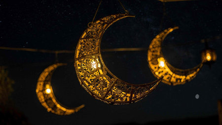 Lanterns in the shape of a crescent in the night.