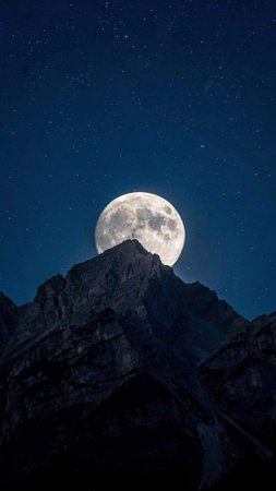 Full moon in the night sky with stars over the mountains