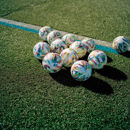 Pile of soccer balls on green field. Soccer ball on grass.