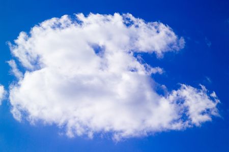 Big white cloud on saturated deep blue skyの写真素材