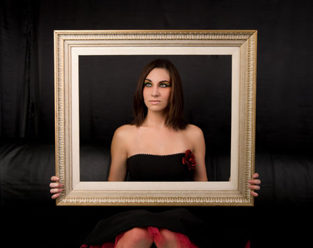 Beautiful young woman holding an antique picture frame