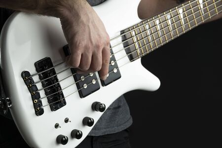 bass guitar player plays white polish finish electric bass guitar, live music.の写真素材