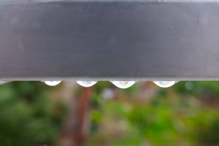 rain drop flowing from the railingの写真素材