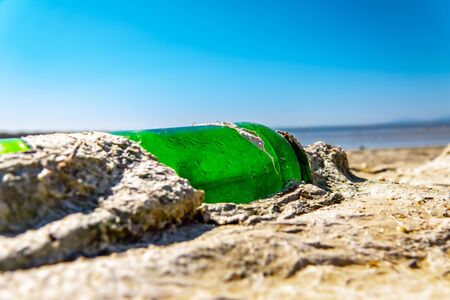 Old bottle floating on the coast, affecting the environmentの写真素材