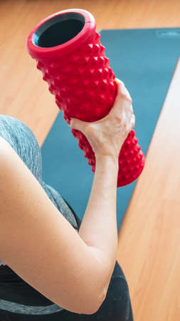 Woman holding the red foam roller.の写真素材